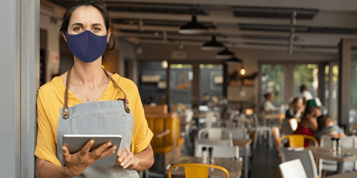 Photo of masked woman at a restaurant.